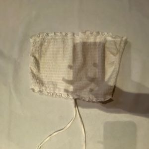 white tube top opened from the back with adjustable strings .